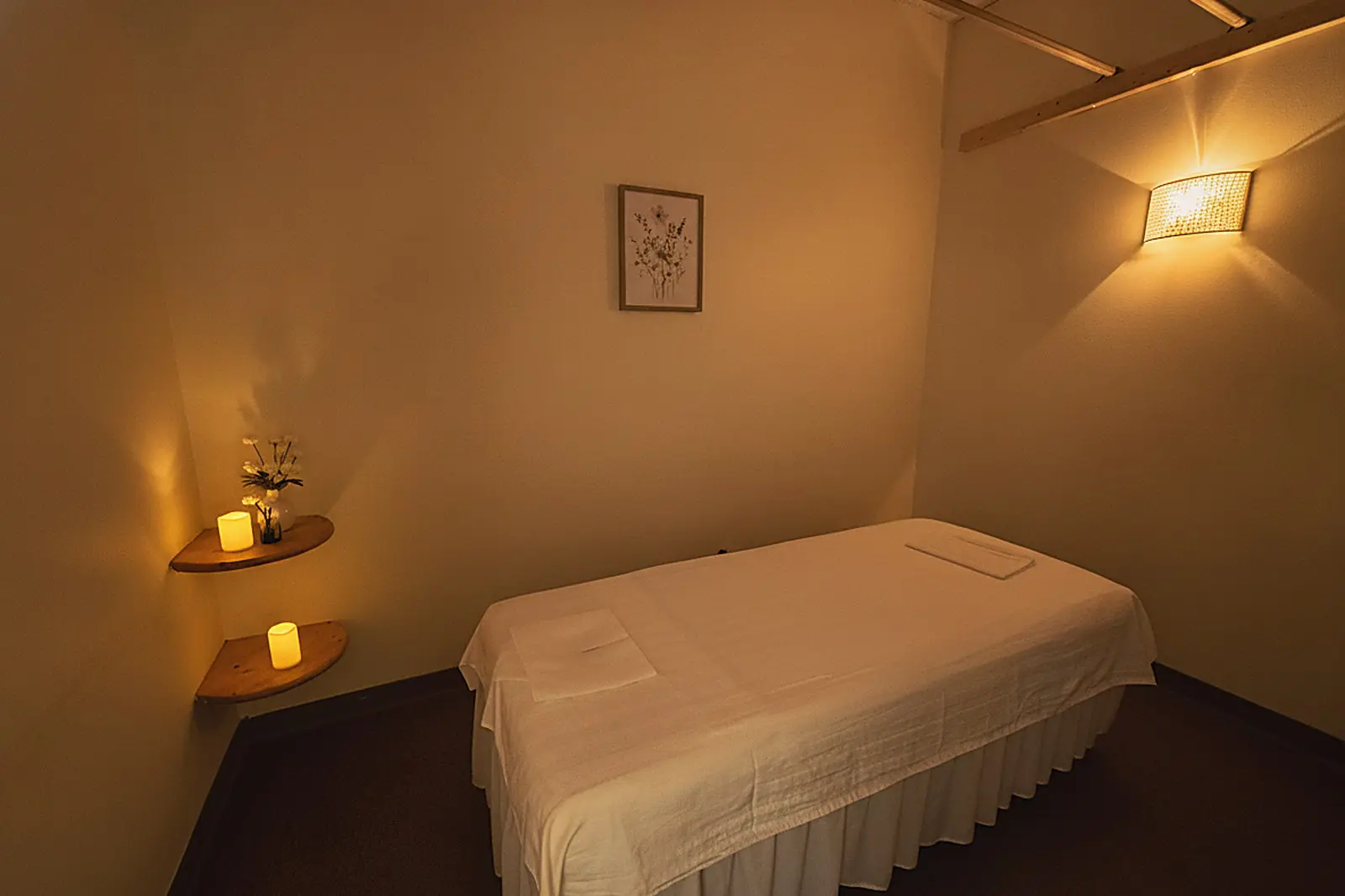 Candlelit treatment room with a draped massage table at Day Massage in Chaska